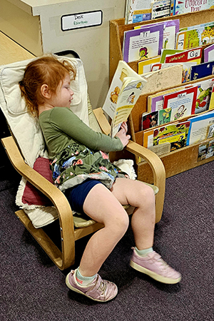 Young child practicing independent reading at early reading skills daycare Bulverde